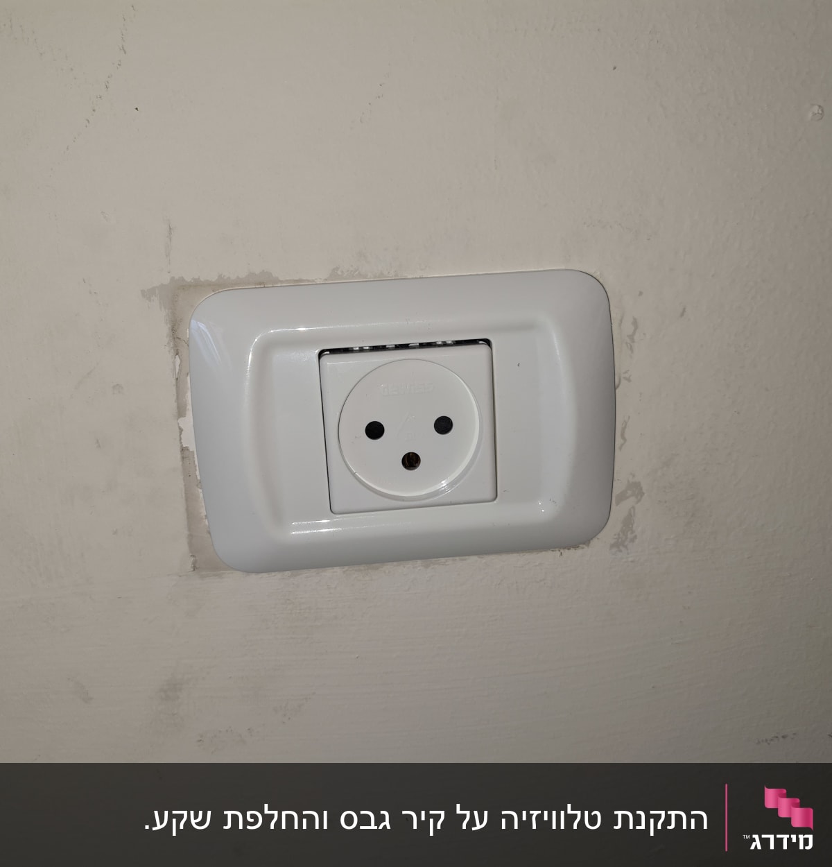 שקע חשמל בקיר עם מסגרת לבנה